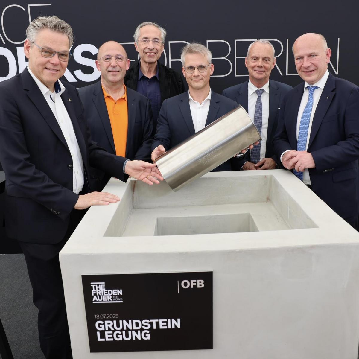 The following individuals are standing around a concrete column, ceremoniously holding a capsule for the foundation stone laying: (from left to right) Jörn Oltmann, Christoph Paul Ritzkat, Sergei Tchoban, Michael Fuchs, Dr. Bernd Schade, Kai Wegner