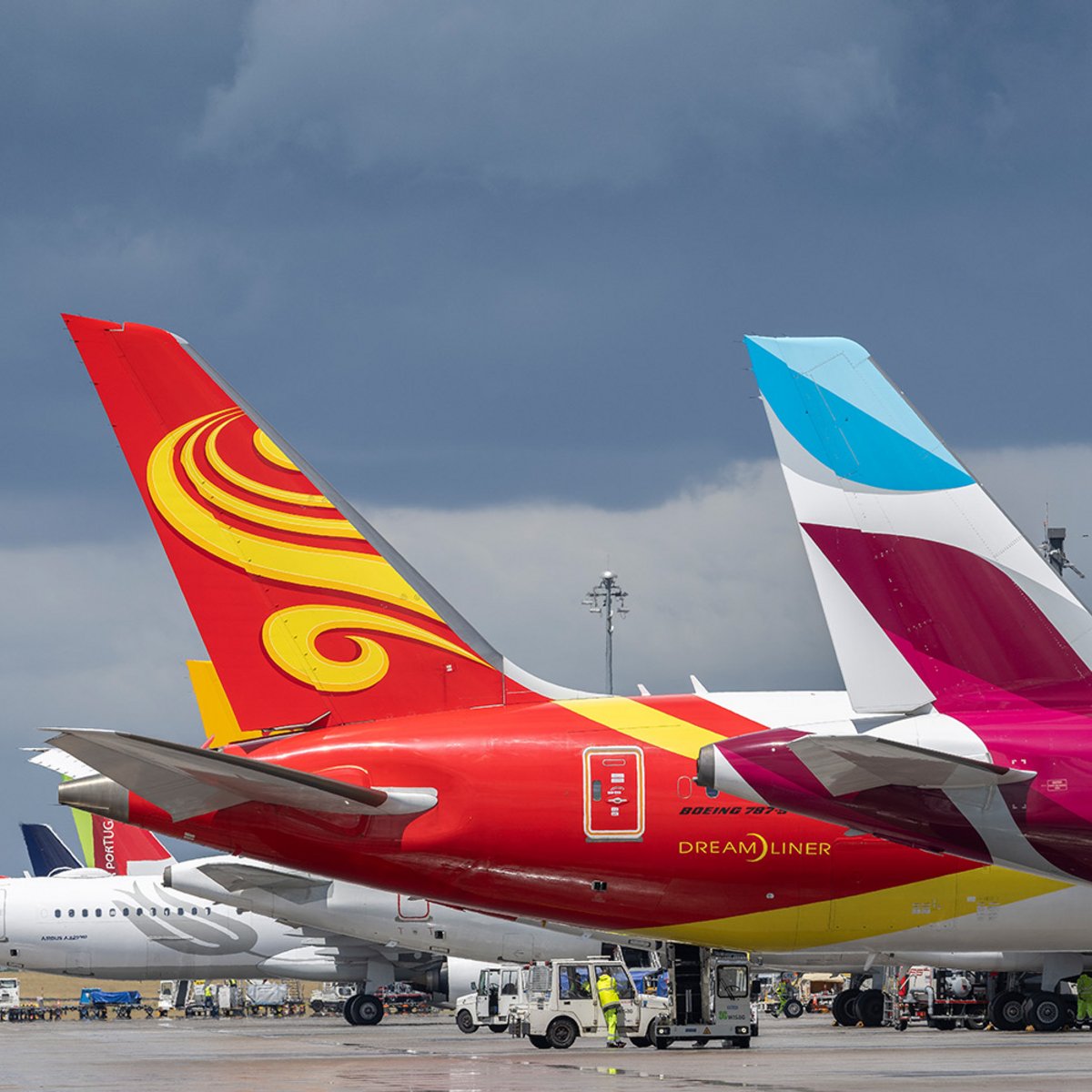 Three large aircraft at Terminal 1 of Berlin Brandenburg Airport (BER), with only the rear half of each fuselage and the tail fin visible.