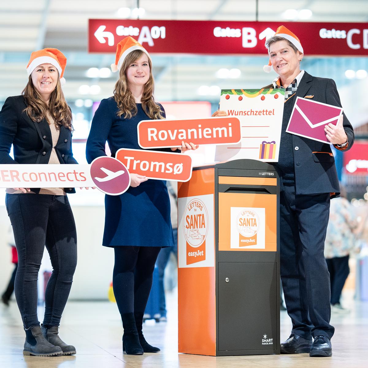  The following people are gathered around the Christmas mailbox at Berlin Brandenburg Airport: In the picture: Jana Friedrich, Senior Manager Business Development Aviation, Flughafen Berlin Brandenburg GmbH (left), Anita Carstensen, Senior PR & PA Manager Germany, Austria & Switzerland, easyJet (center), and Dany, easyJet crew (right).