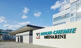 You can see the entrance gate and a part of the main building of Berlin-Chemie, a Berlin pharmaceutical company, the logo of the company is placed at the entrance, in turquoise letters.