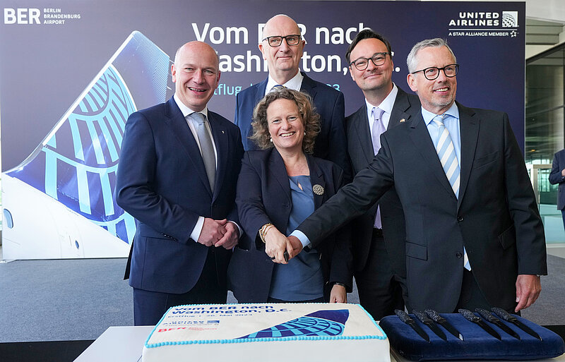 Ceremonial cake cutting for the inaugural United Airlines flight to Washington D.C. with the following people: Kai Wegner, Governing Mayor of Berlin; Aletta von Massenbach, Chairwoman of the Management Board of Flughafen Berlin Brandenburg GmbH; Dr. Dietmar Woidke, Minister President of the State of Brandenburg; Parliamentary State Secretary Oliver Luksic, Member of the Bundestag for the Federal Minister of Digital Affairs and Transport; Thorsten Lettnin, Director Sales Continental Europe, Middle East, Africa, India and Israel, United Airlines.
