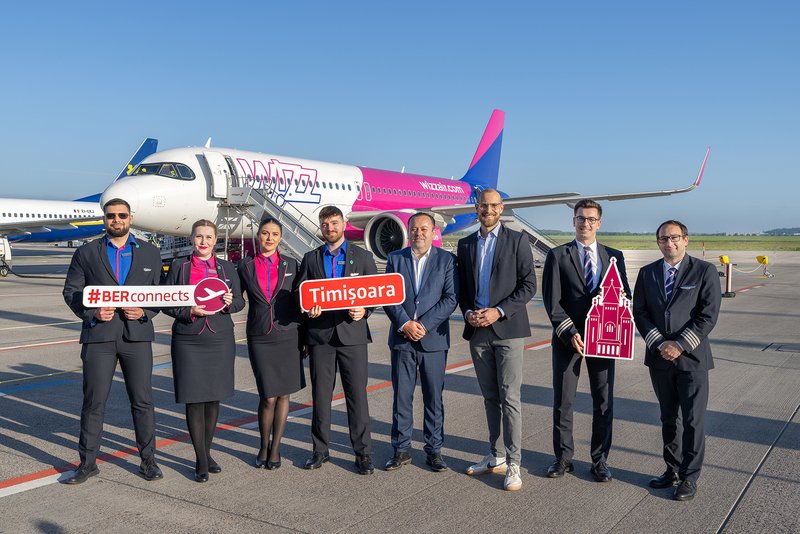 The following people are holding advertising signs in front of a Wizz Air aircraft: Alin Popoviciu (5th from left) and Johannes Mohrmann (6th from left), together with the Wizz Air crew.