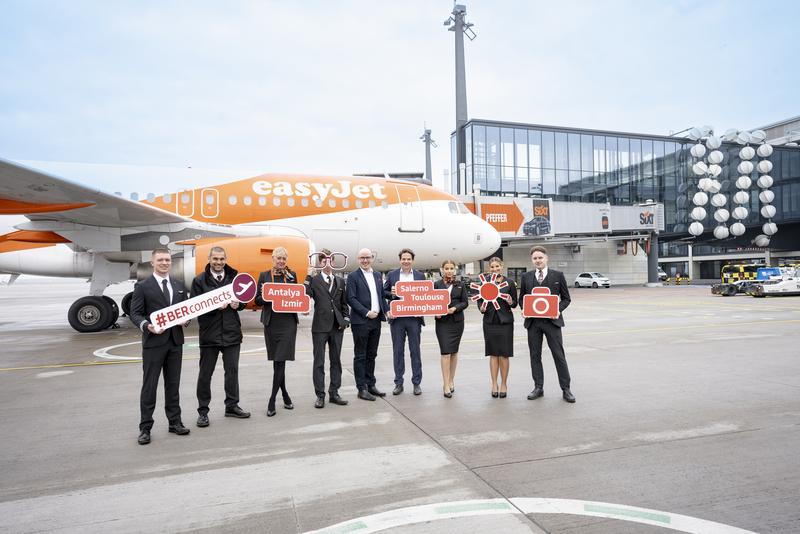 Crew in front of easyjet aircraft on the tarmac at BER with the passengers: In the picture: Stephan Erler, Country Manager Germany & Switzerland, easyJet (centre) and Thomas Kohr, Head of Corporate Business Development, Flughafen Berlin Brandenburg GmbH (4th from right) surrounded by the crew.