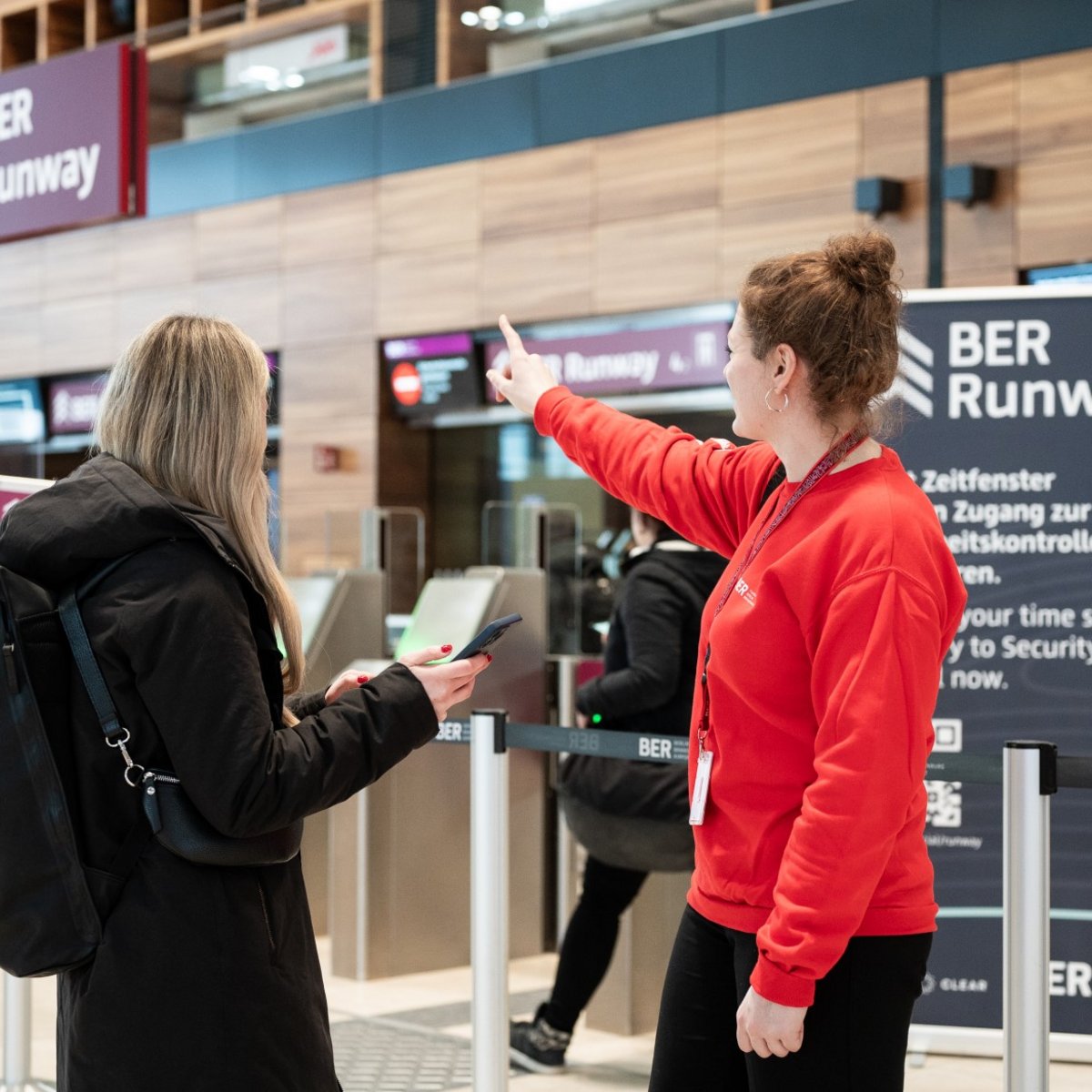 Passenger with a BER employee in front of the BER Runway - Security check on the news topic: BER wins Airport Innovation Award 2023