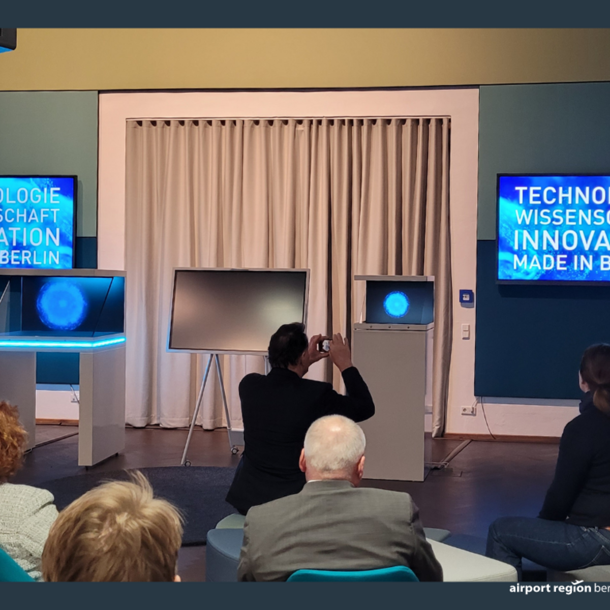 Demonstration in the 5G showroom at WISTA Adlershof, guests watch and listen intently.