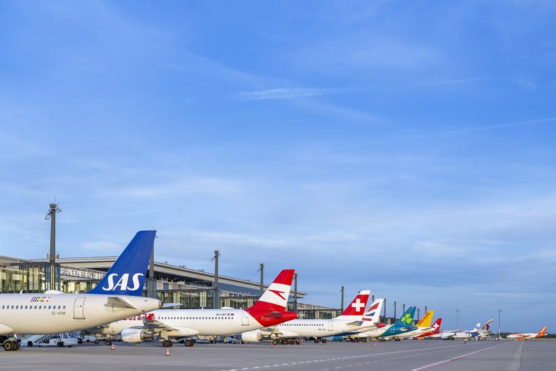 Promo image for the announcement: FBB secures early refinancing of 1.2 billion euros, various aircraft on the apron at Berlin Brandenburg Airport.