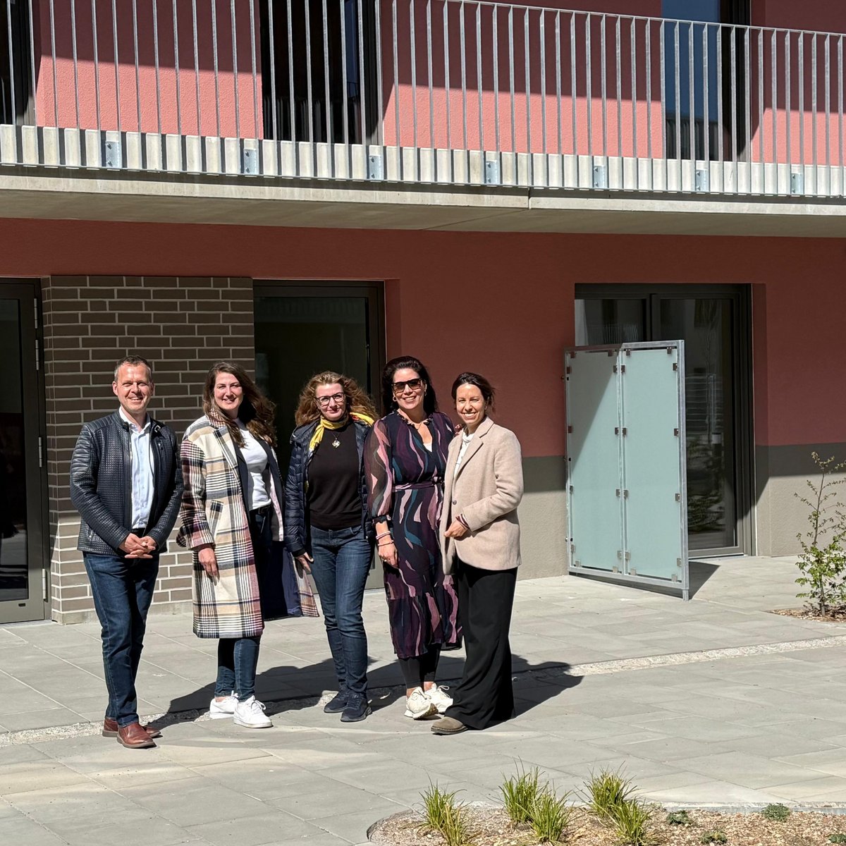The following people are standing in front of a building in the QUARTERBACK Immobilien AG quarter (from left to right): Steffen Voigt (Managing Director, ImmVest Wolf GmbH); Nina Börner (Asset Manager, HIH Real Estate GmbH); Melanie Splichal (Branch Manager, Potsdam Branch); Ulrike Klein (Technical Project Manager, HIH Real Estate GmbH); Merle Gossel (Asset Manager, HIH Real Estate GmbH).