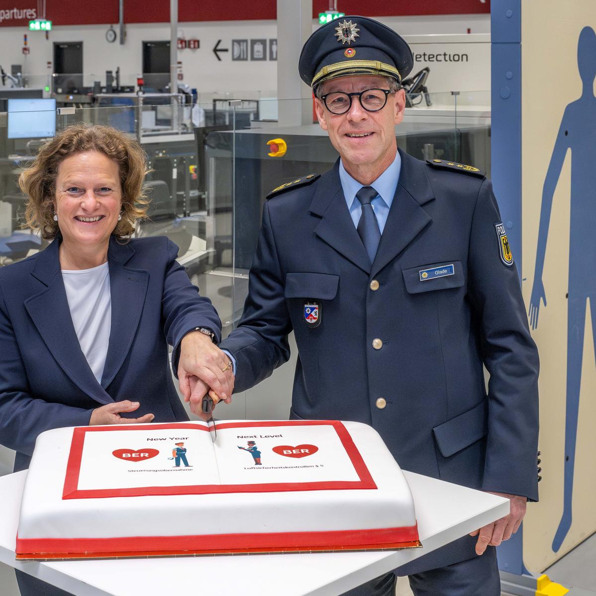 Picture of the takeover of aviation security control by FBB at the cutting of a cake: from left to right Aletta von Massenbach, Chairwoman of the Management Board of Flughafen Berlin Brandenburg GmbH and Carsten Glade, President of the Berlin Federal Police