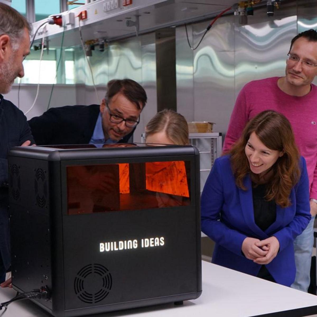 People examine and admire the Xube, a new type of 3D printer from Xolo Gmbh in Berlin Adlershof