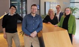The following people stand together at a table: Dr. Ta-Shun Chou, Dr. Andreas Popp, Dr. Maike Schröder, Prof. Dr. Thomas Schröder, Dr. Janet Zapke