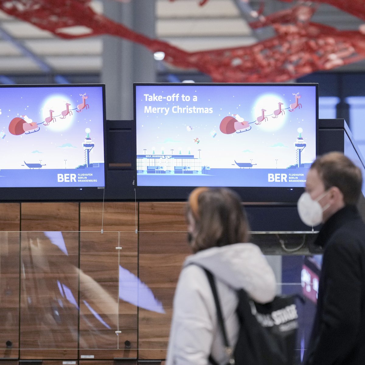 Abfertigungshalle BER mit Weihnachtsgruß auf dem Display