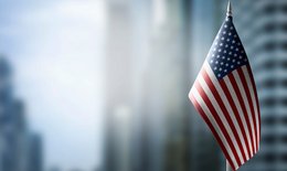 Flag of USA in foreground, background blurred building