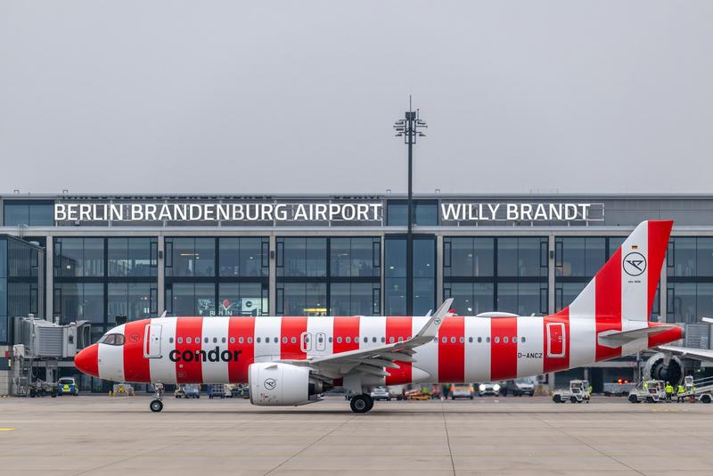Condor aircraft in red and white stripes in front of Terminal 1, on the apron at Berlin Brandenburg Airport